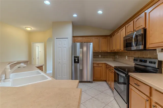 a kitchen with stainless steel appliances granite countertop a refrigerator and a stove top oven