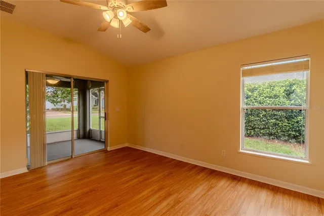 a view of wooden floor and a chandelier fan in a room