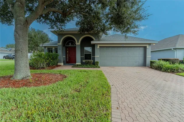 a front view of a house with yard and garage