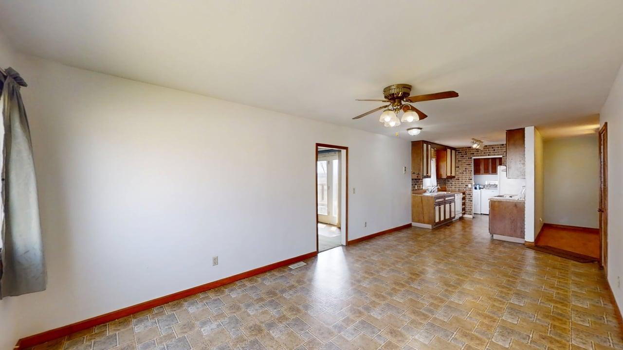 1002 Goldenview Drive Champaign, IL 61821 - Photo 8 of 38 a view of a livingroom with a ceiling fan a kitchen space with wooden floor and a ceiling fan
