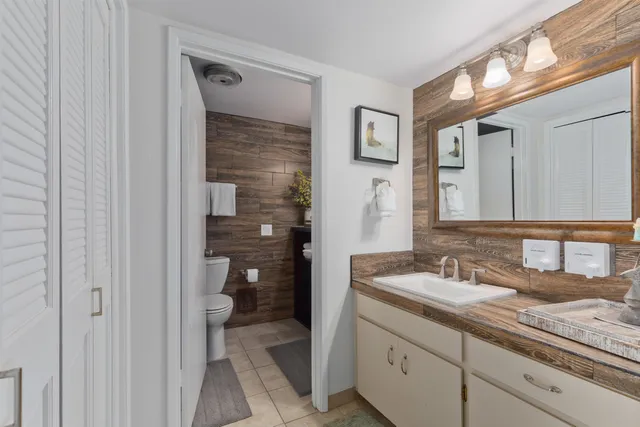 a en suite bathroom with a granite countertop sink and a mirror