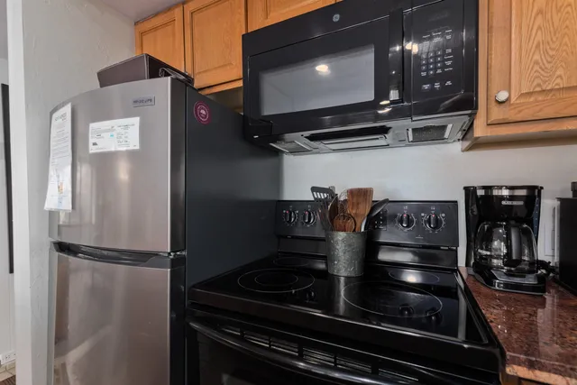 a kitchen with stainless steel appliances granite countertop a refrigerator and a stove top oven