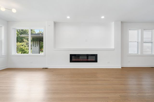 an empty room with wooden floor and a window