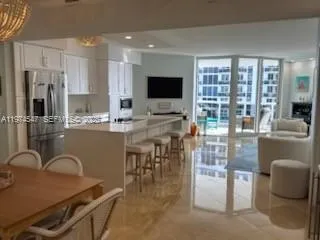 a kitchen with stainless steel appliances granite countertop a stove top oven a sink a dining table and chairs
