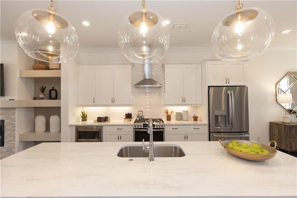 a kitchen with stainless steel appliances a sink dining table and chairs