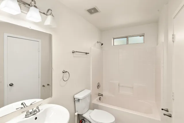 a bathroom with a sink toilet tub and shower