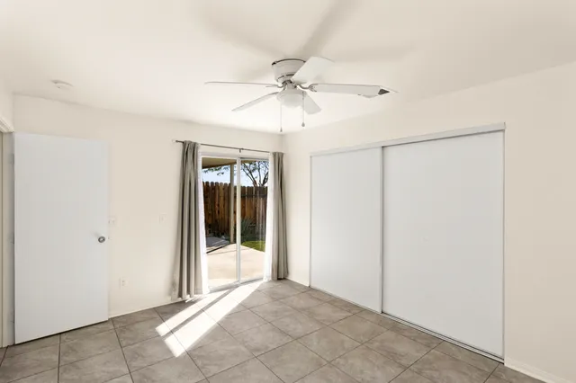a view of a big room with a chandelier fan and windows