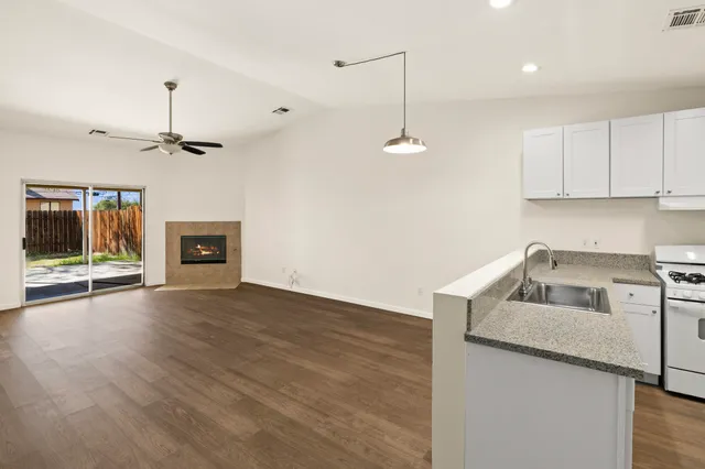 a kitchen with kitchen island a stove a sink and a fireplace