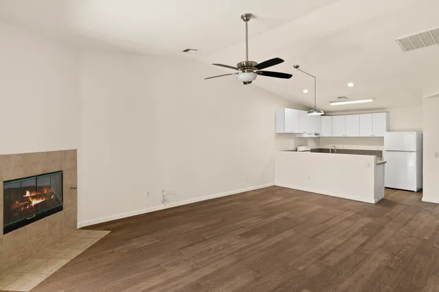 a view of a kitchen with a sink wooden floor a refrigerator and window
