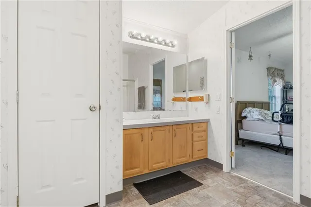 a spacious bathroom with a double vanity sink a mirror and a bathtub