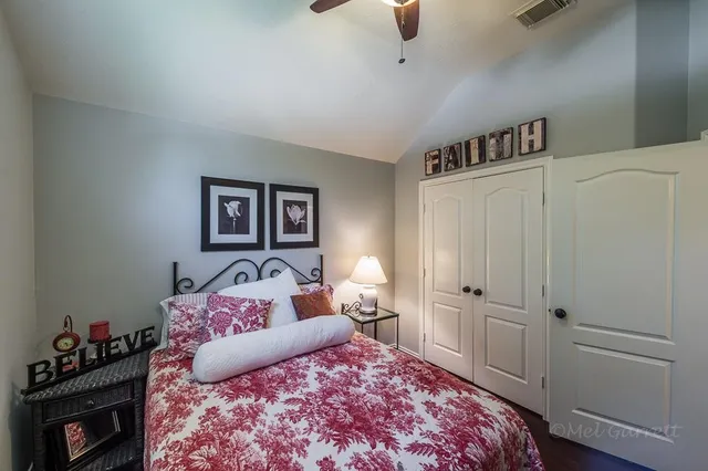 a bedroom with a bed and a lamp on the dresser