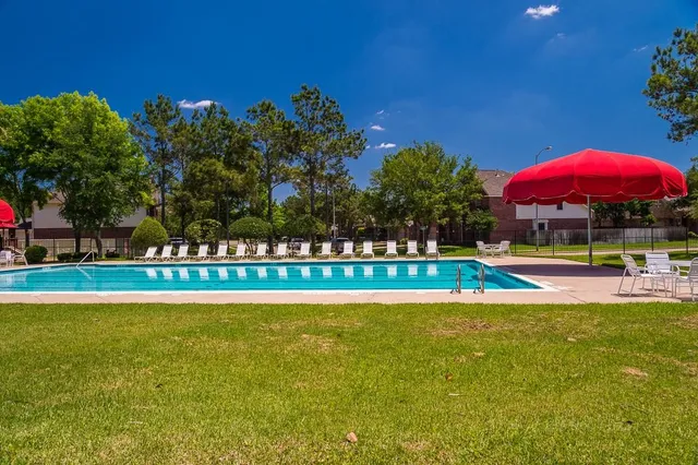 a view of a swimming pool with a patio and a yard