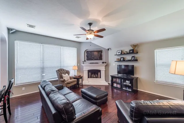 a living room with furniture a fireplace and a flat screen tv
