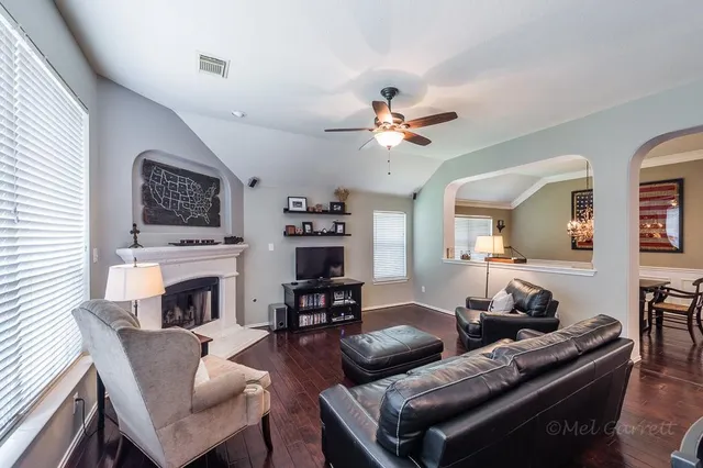 a living room with furniture a fireplace and a flat screen tv