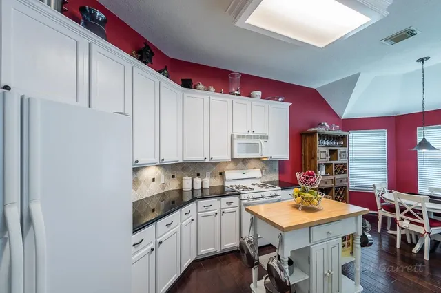 a kitchen with a sink a stove and chairs