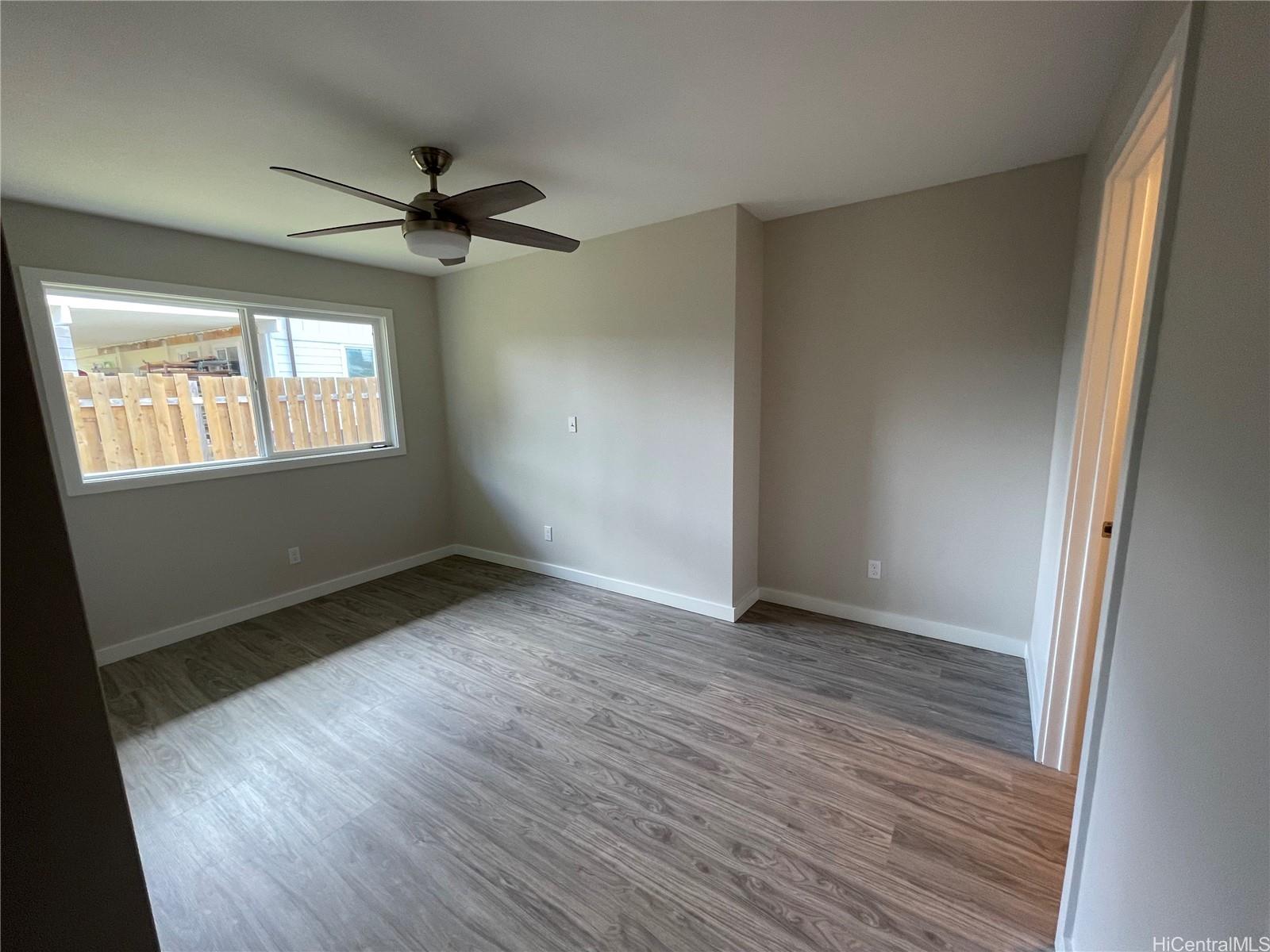 45-143 William Henry Road, Unit D Kaneohe, HI 96744 - Photo 8 of 9 an empty room with wooden floor fan and windows