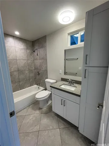 a bathroom with a granite countertop sink a toilet and shower