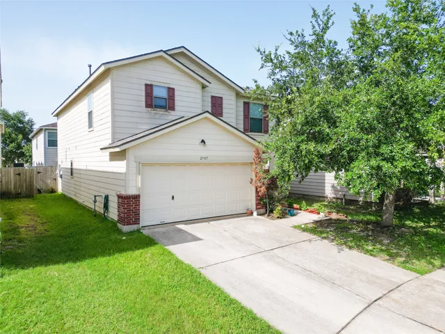a front view of a house with a yard and trees