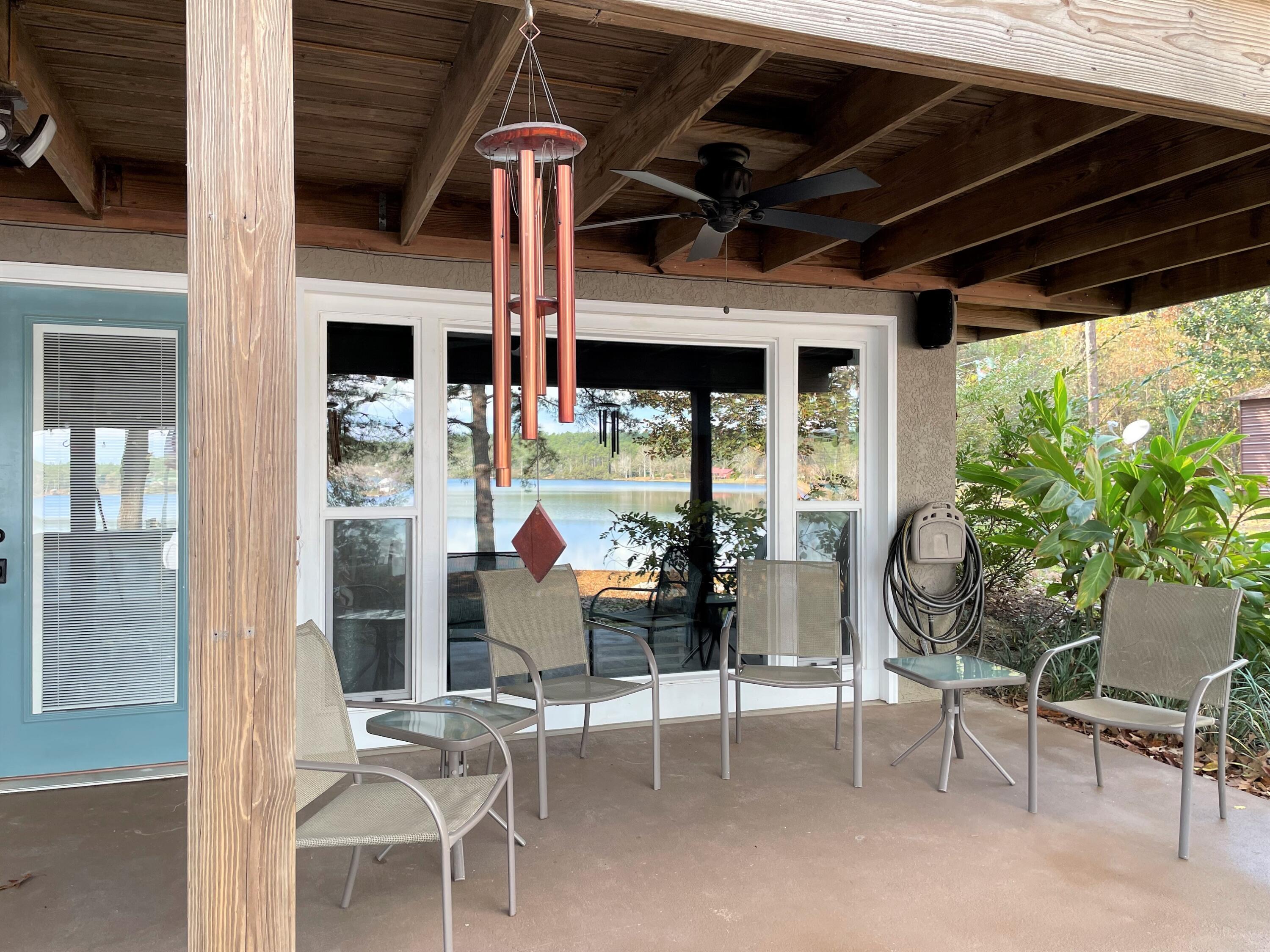 914 Spring Lake Road DeFuniak Springs, FL 32433 - Photo 28 of 78 a view of a patio with table and chairs potted plants