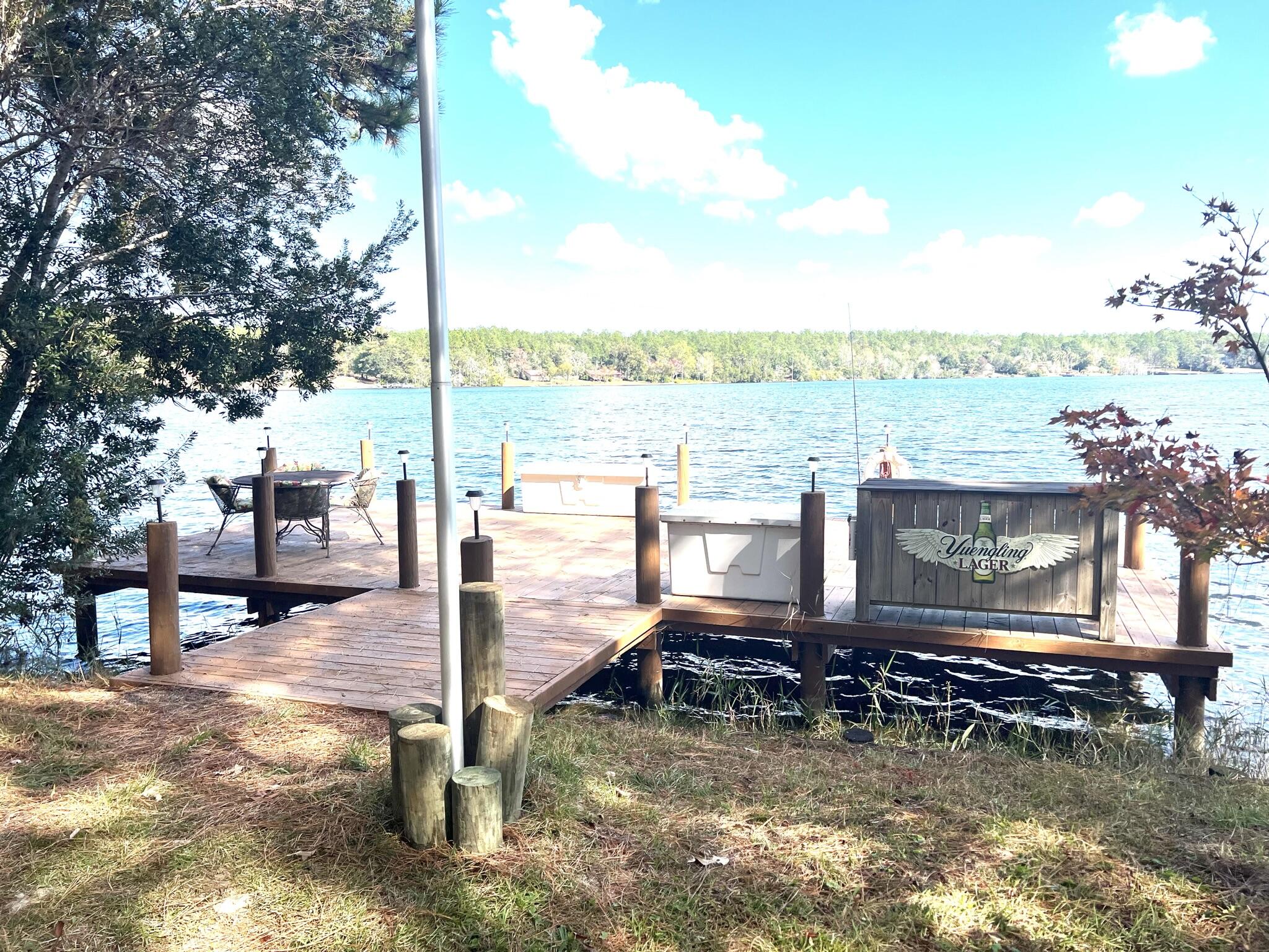 914 Spring Lake Road DeFuniak Springs, FL 32433 - Photo 45 of 78 a wooden bench sitting next to a lake