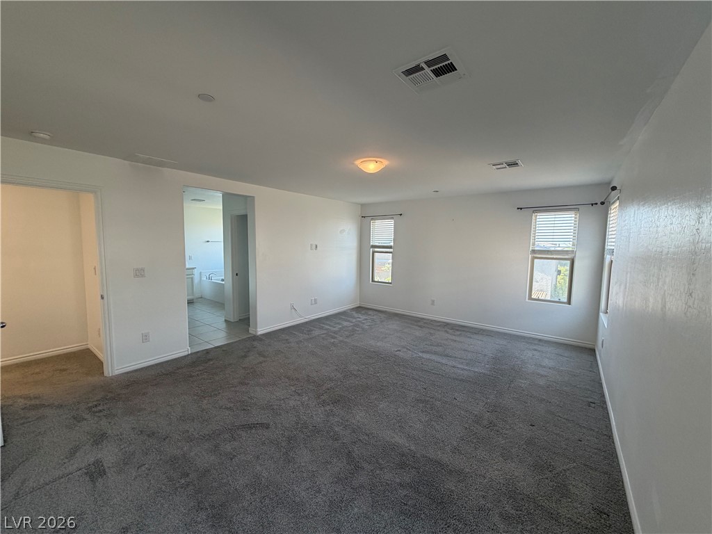 3228 Azalea Ridge Court Henderson, NV 89052 - Photo 7 of 28 Comfortable carpeting and ample natural light define this inviting primary bedroom retreat.