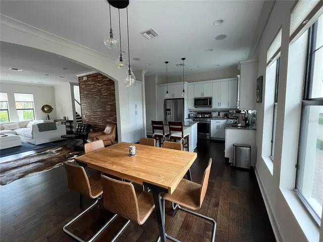 a kitchen with a dining table chairs and refrigerator