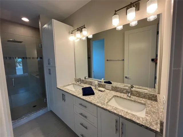 a bathroom with a granite countertop sink a toilet and shower