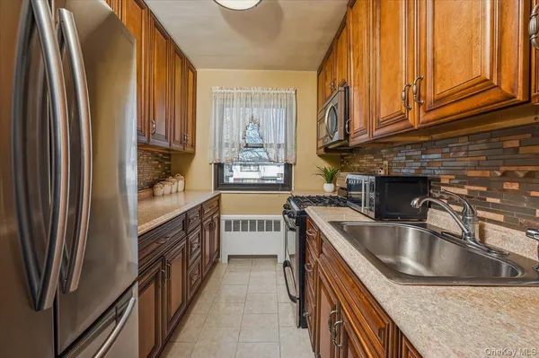 a kitchen with stainless steel appliances granite countertop a sink and a refrigerator