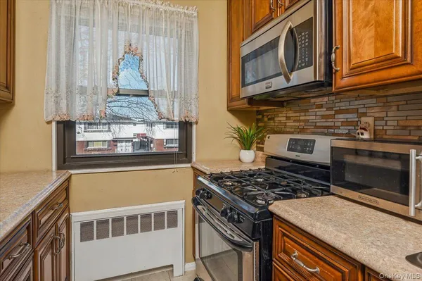 a kitchen with stainless steel appliances granite countertop a stove and a microwave
