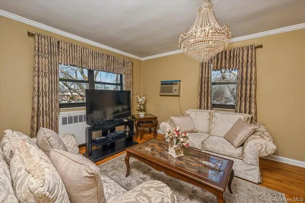 a living room with furniture a chandelier and a flat screen tv