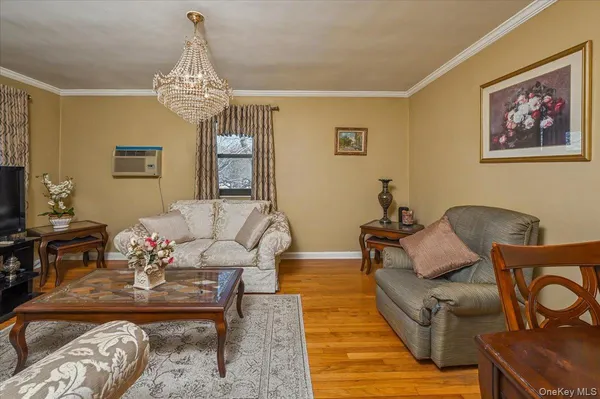a living room with furniture chandelier and a table