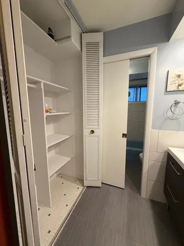 a view of walk in closet with empty racks