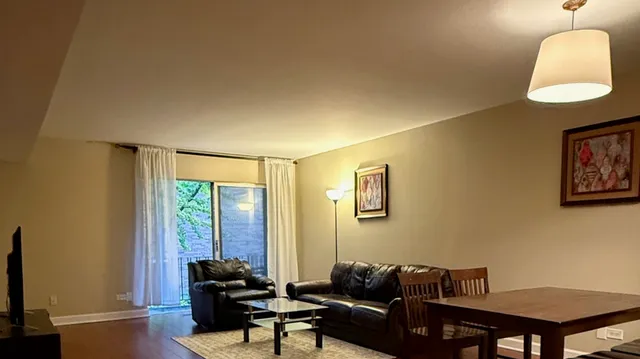 a living room with furniture a window and a flat screen tv