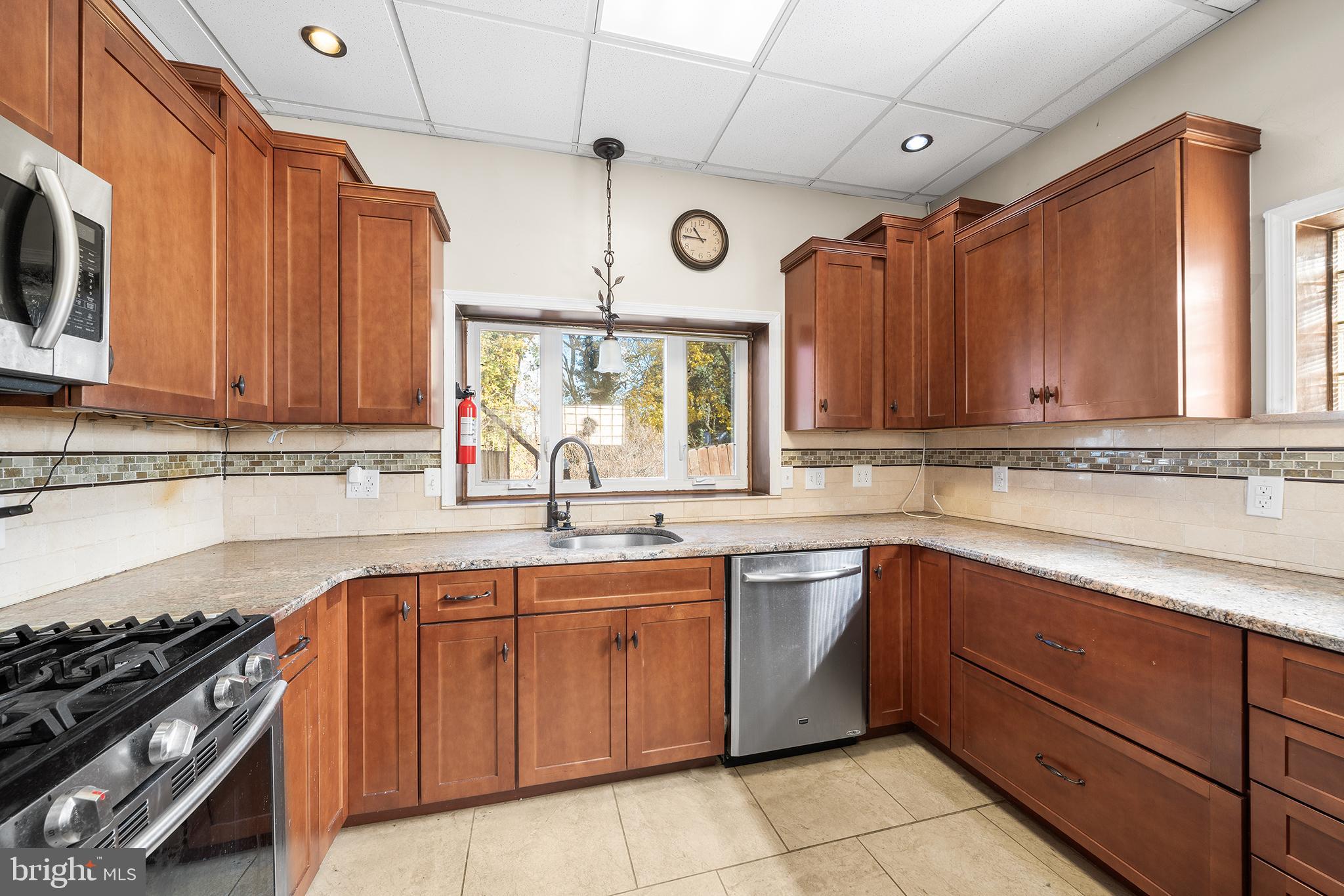 7301 Chestnut Avenue, Unit 1 Elkins Park, PA 19027 - Photo 3 of 22 a kitchen with a sink stove top oven and cabinets