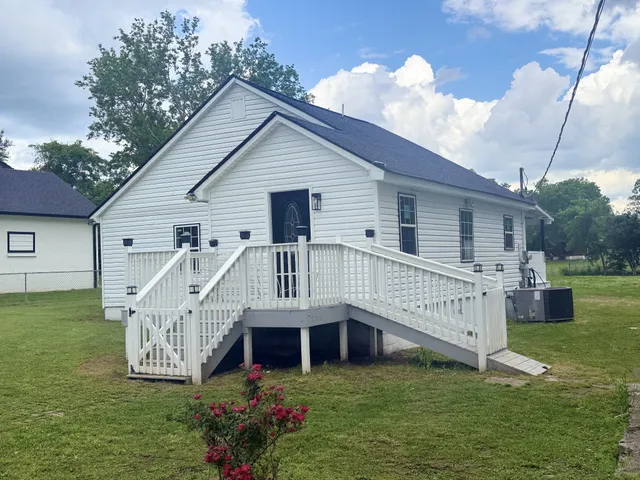 a view of a house with a yard deck and a garden