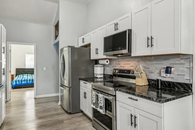 a kitchen with stainless steel appliances a stove a microwave a sink and cabinets