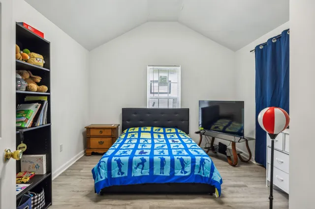 a bedroom with a bed a dresser and book shelf
