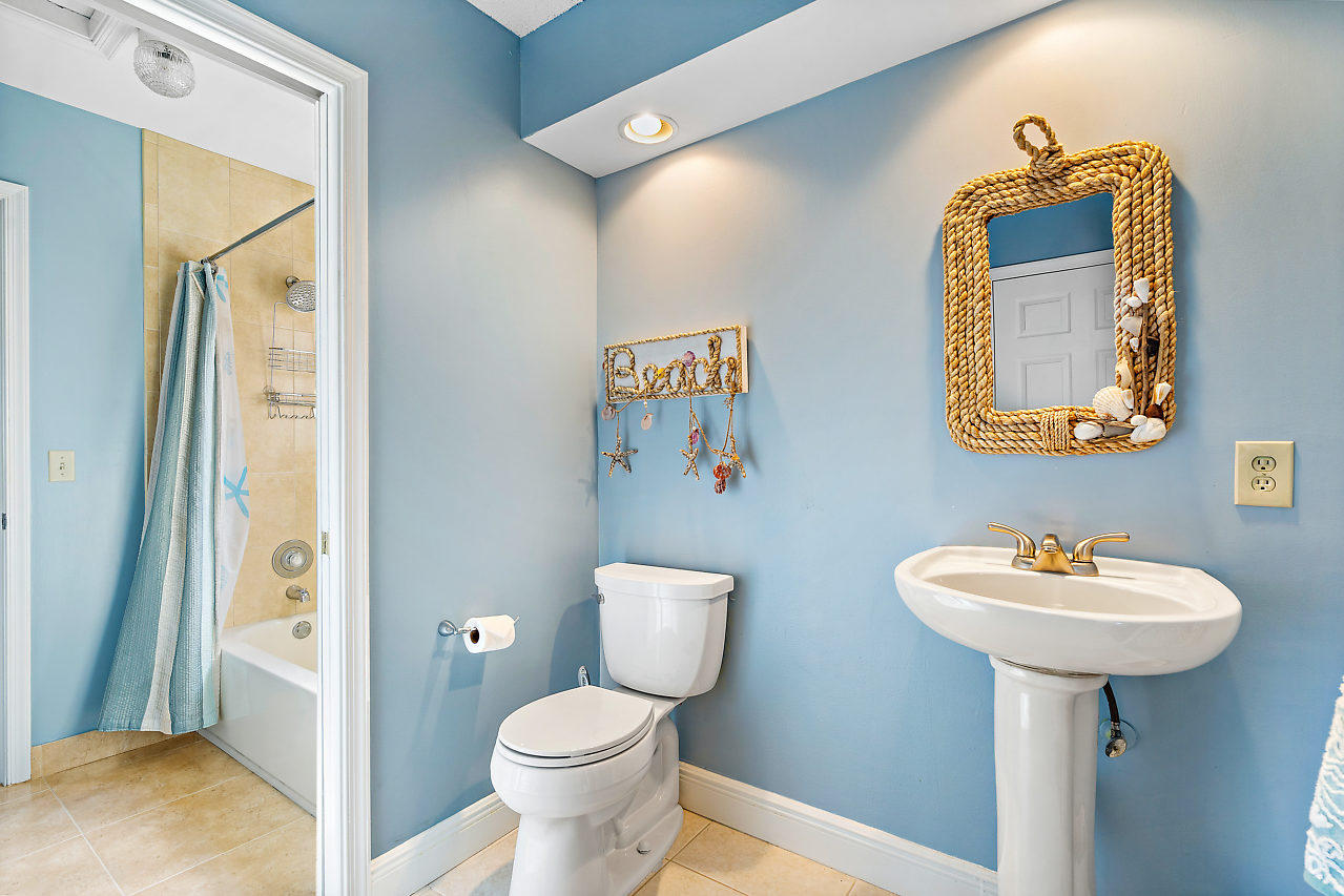 23122 Island View, Unit 6 Boca Raton, FL 33433 - Photo 19 of 38 a bathroom with a toilet sink and mirror