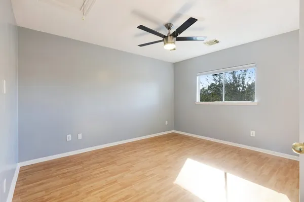 a view of a big room with wooden floor and windows