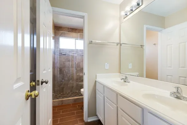a bathroom with a shower sink and mirror