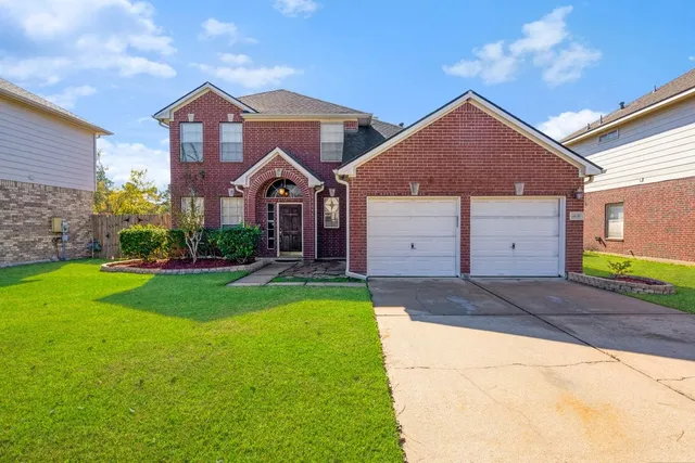a front view of a house with a yard and garage