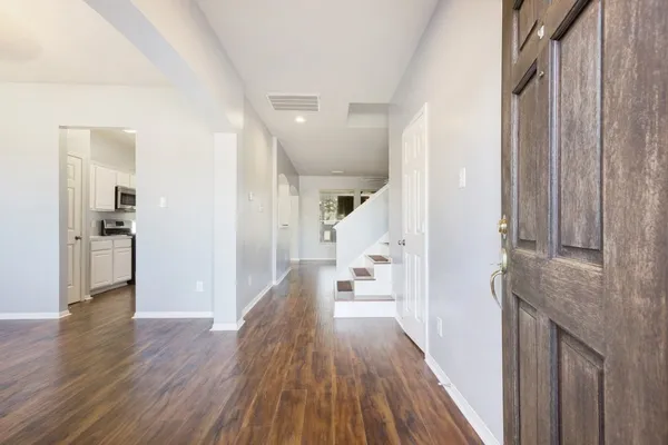 a view of a hallway with wooden floor and staircase