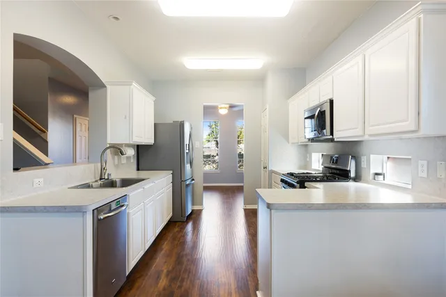 a kitchen with stainless steel appliances granite countertop a sink stove and refrigerator