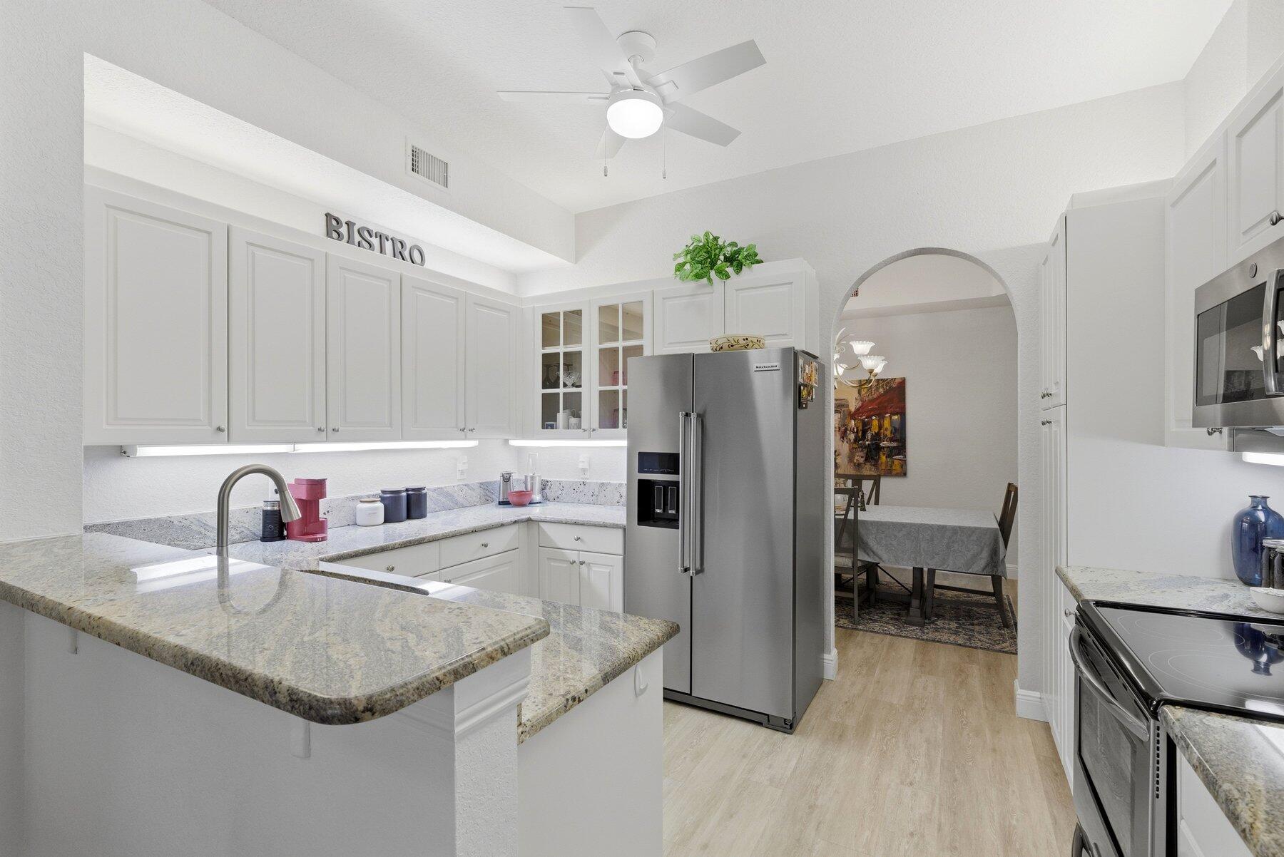 7961 Exeter Boulevard East, Unit 102 Tamarac, FL 33321 - Photo 15 of 46 a kitchen with refrigerator and cabinets
