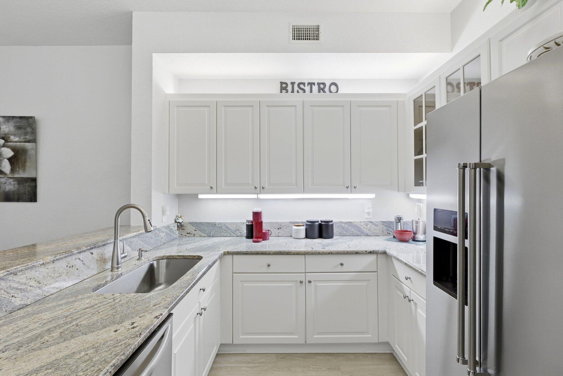 7961 Exeter Boulevard East, Unit 102 Tamarac, FL 33321 - Photo 16 of 46 a kitchen with stainless steel appliances granite countertop a sink refrigerator and cabinets