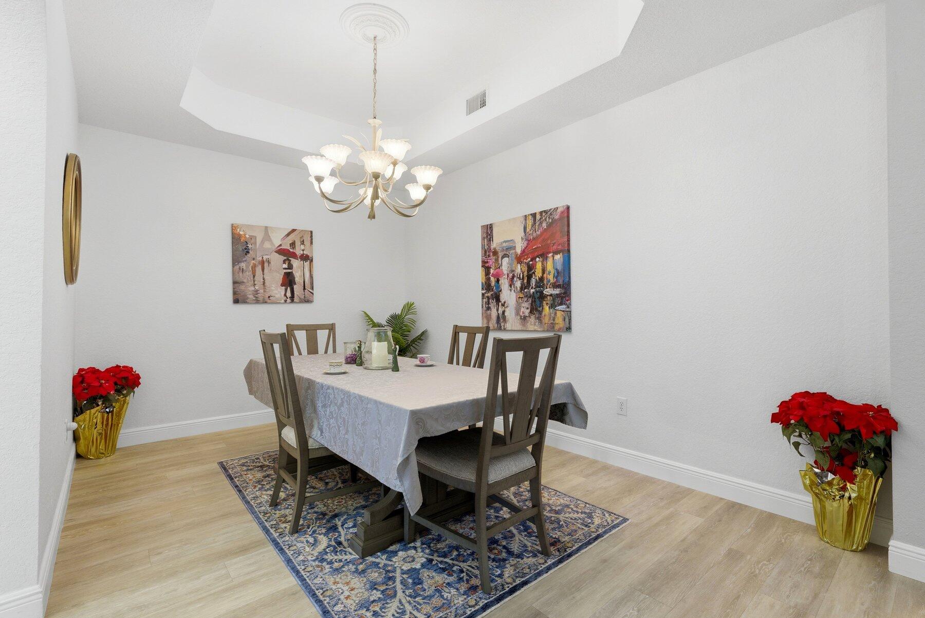 7961 Exeter Boulevard East, Unit 102 Tamarac, FL 33321 - Photo 18 of 46 a dining room with furniture a chandelier and wooden floor