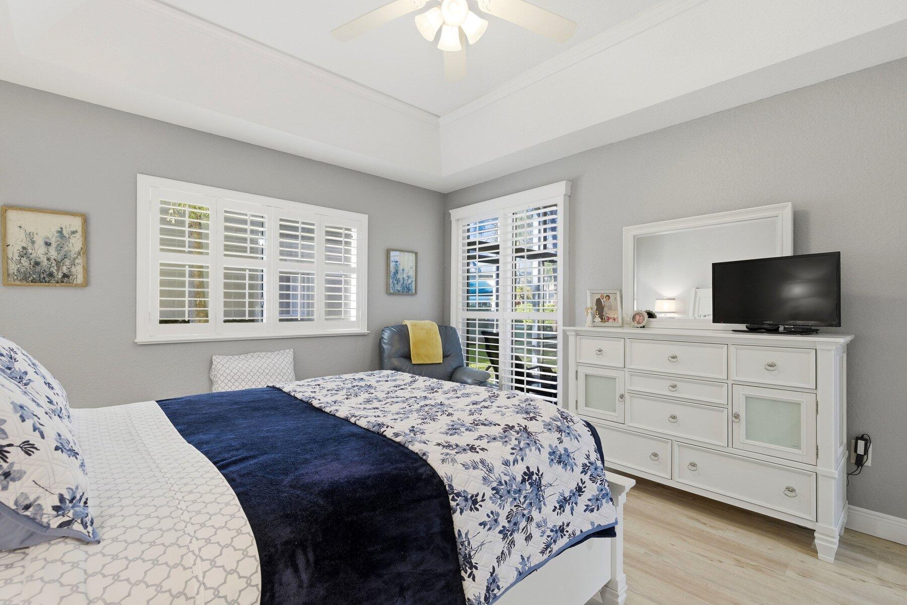 7961 Exeter Boulevard East, Unit 102 Tamarac, FL 33321 - Photo 20 of 46 a bedroom with a large bed and a flat screen tv