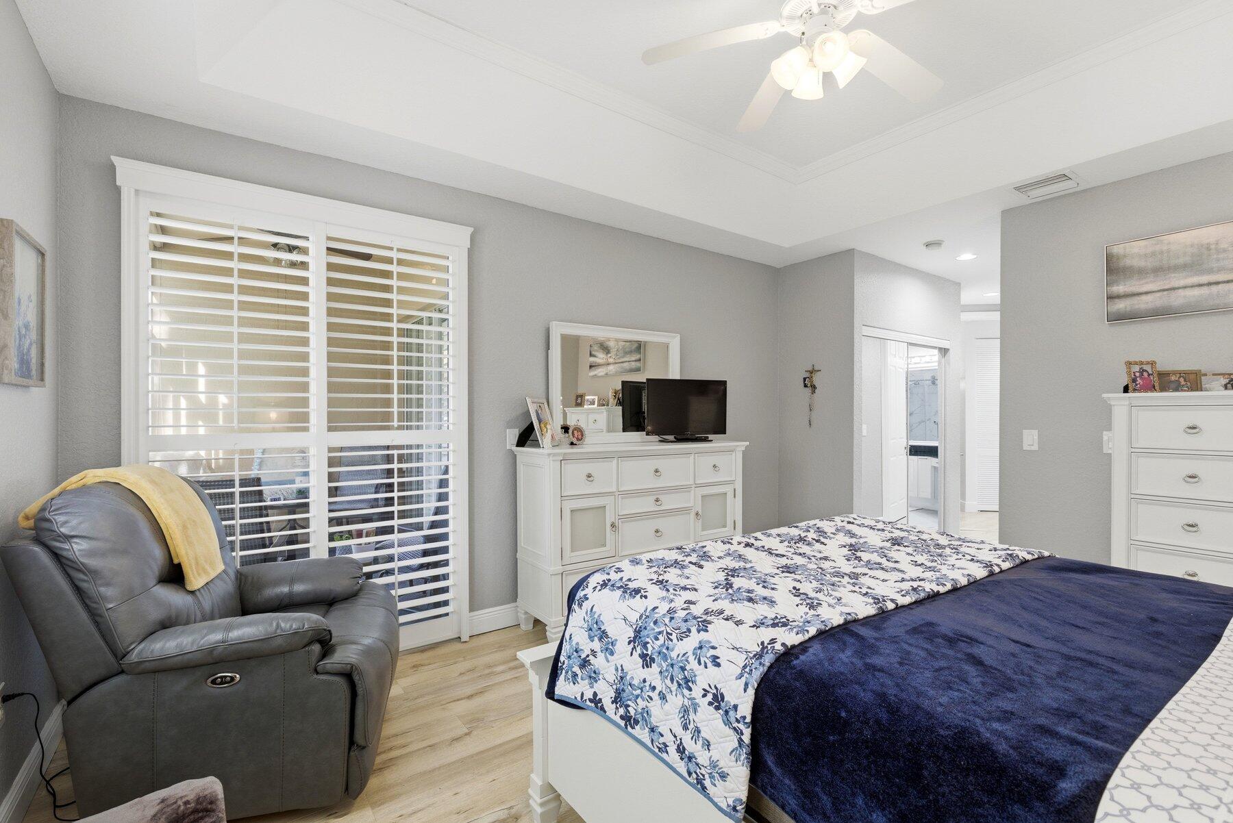 7961 Exeter Boulevard East, Unit 102 Tamarac, FL 33321 - Photo 21 of 46 a bedroom with a bed a couch and a flat screen tv