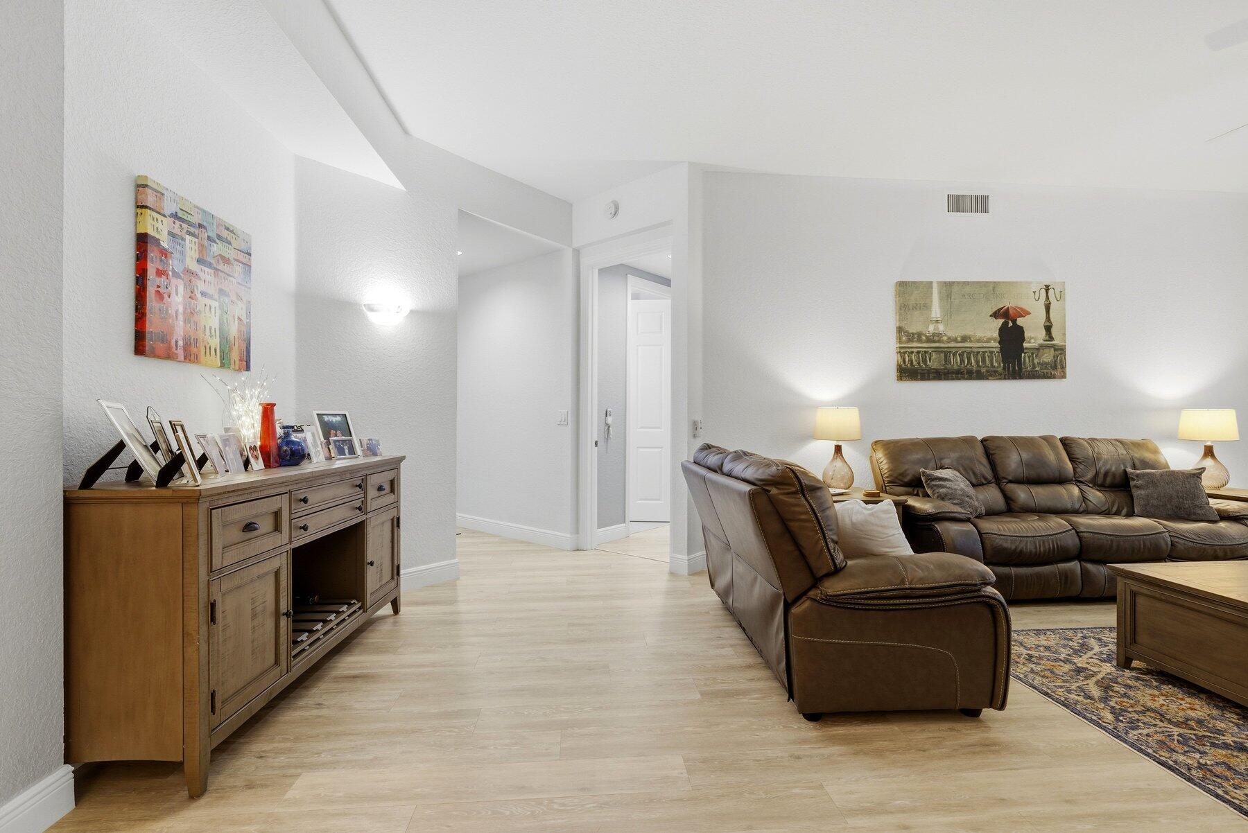 7961 Exeter Boulevard East, Unit 102 Tamarac, FL 33321 - Photo 3 of 46 a living room with furniture and a fireplace