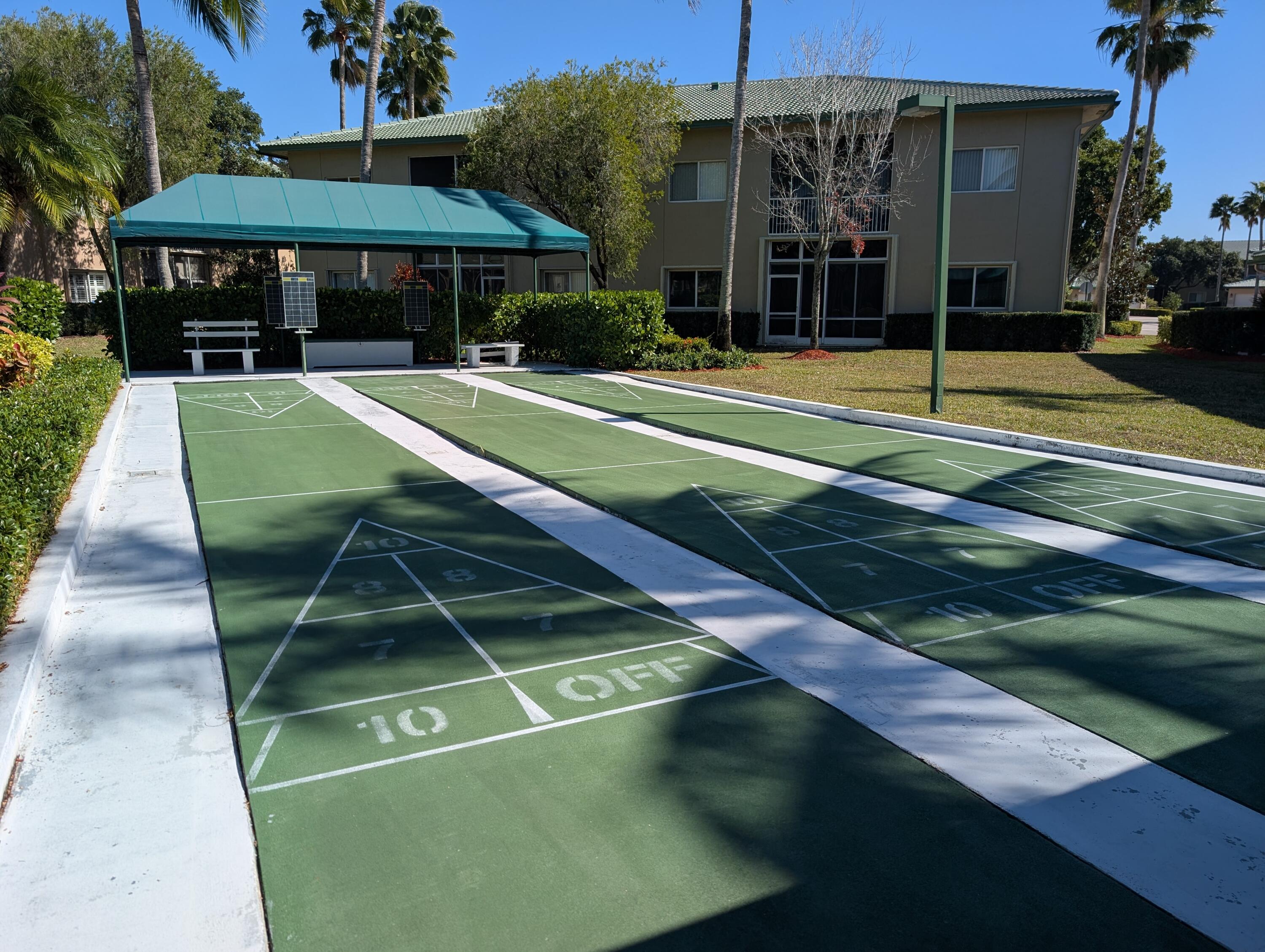 7961 Exeter Boulevard East, Unit 102 Tamarac, FL 33321 - Photo 32 of 46 a view of a tennis ground with large trees
